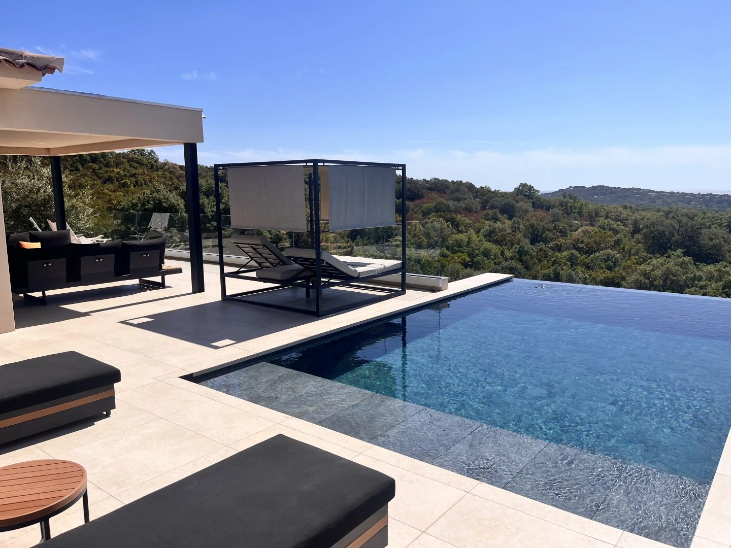 La piscine à débordement de la villa, le lit de repos sous voile et le maquis à perte de vue.